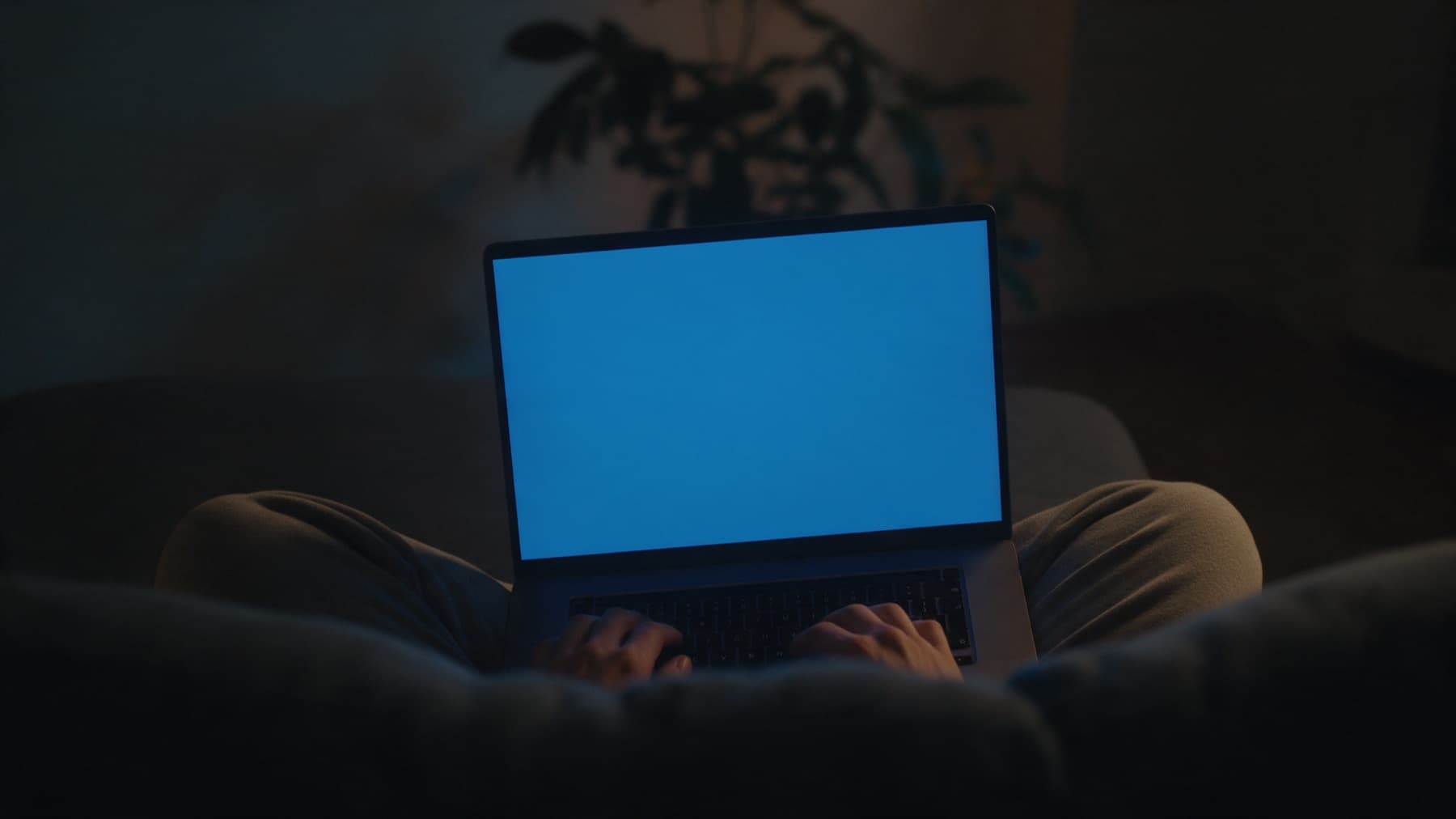 Pessoa usando o notebook no sofá à noite, foto ilustrativa gerada por IA